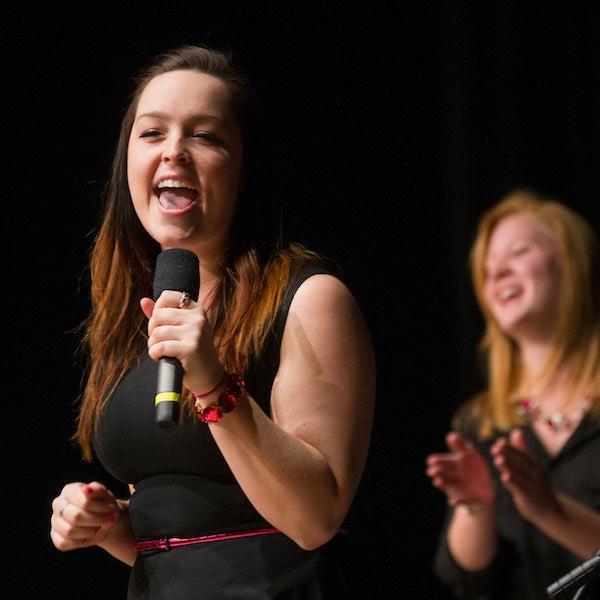 A young woman singing in an accapella competition