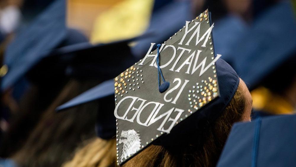 A close up of a grad cap that says "My Watch Has Ended" in a game of thrones reference.