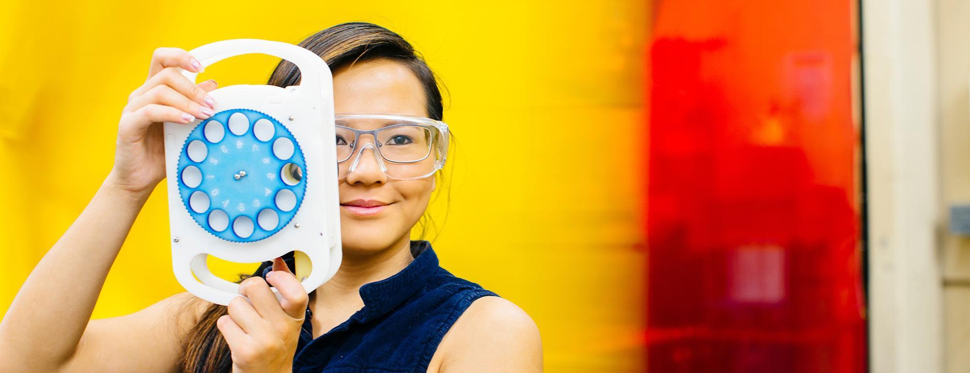 A student poses with her optomalogic invention