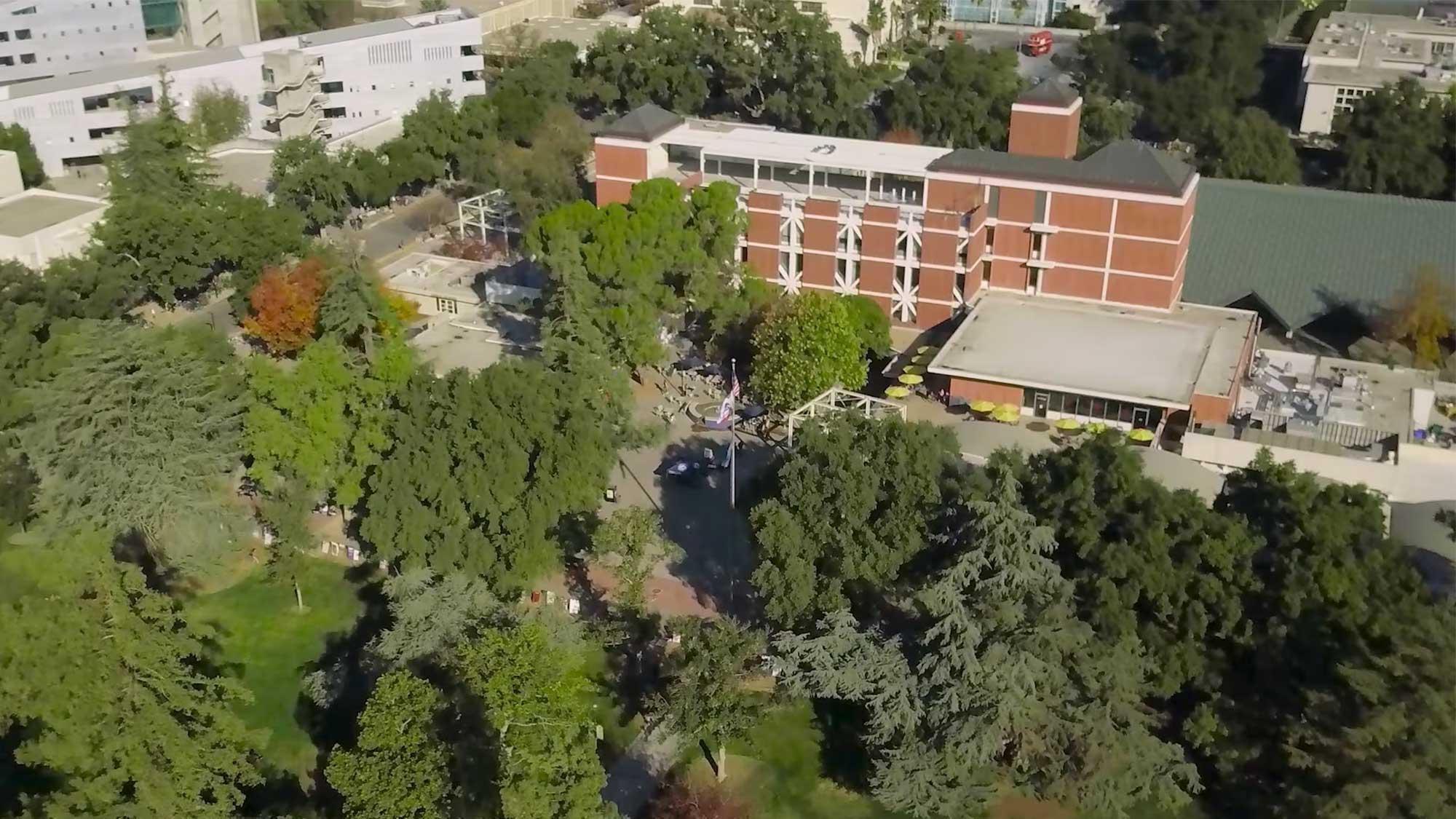 aerial view of the UC Davis campus showing some buildings surrounded by trees
