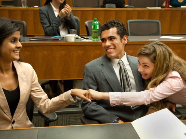 students fist bump after a win at the law school