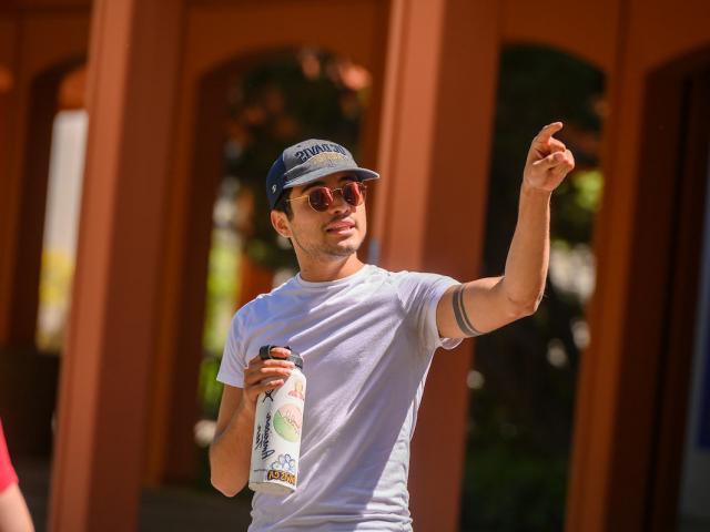 A tour guide pointing out a UC Davis campus landmark