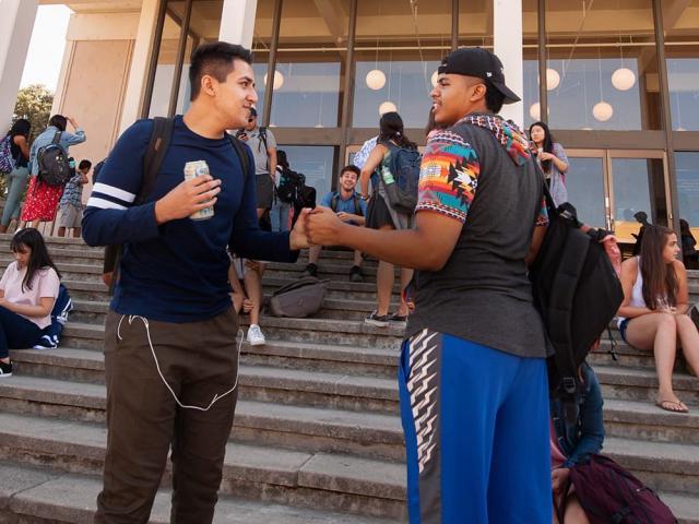 two students chatting on steps in front of building - transfer application tips