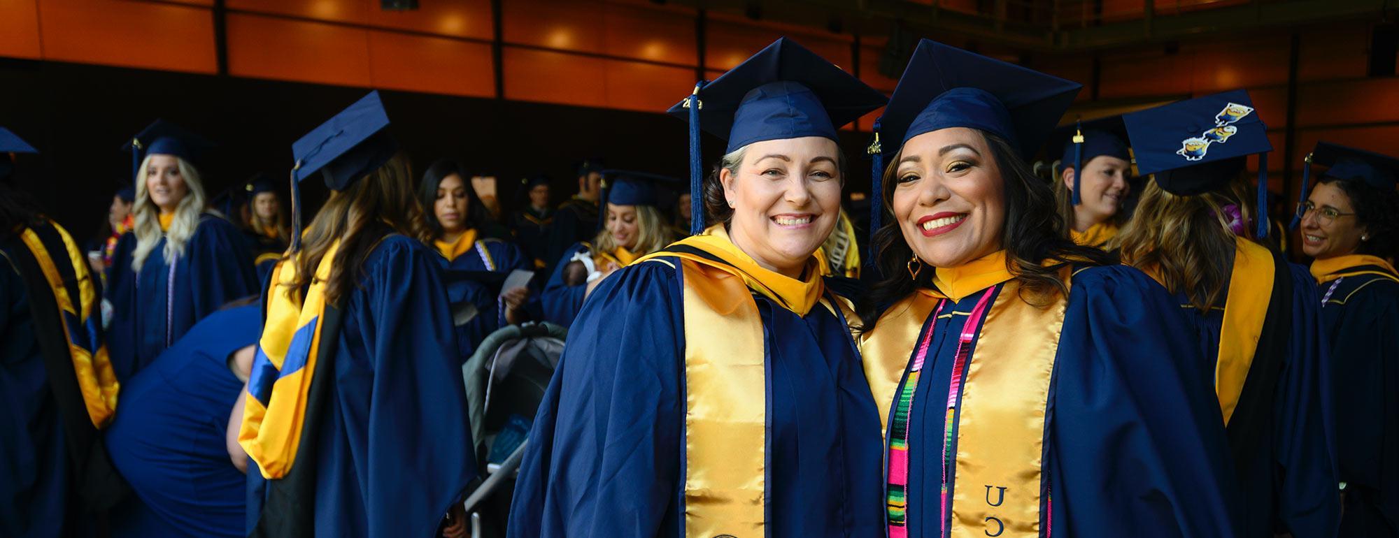 Two nursing school students celebrate during their graduation ceremony