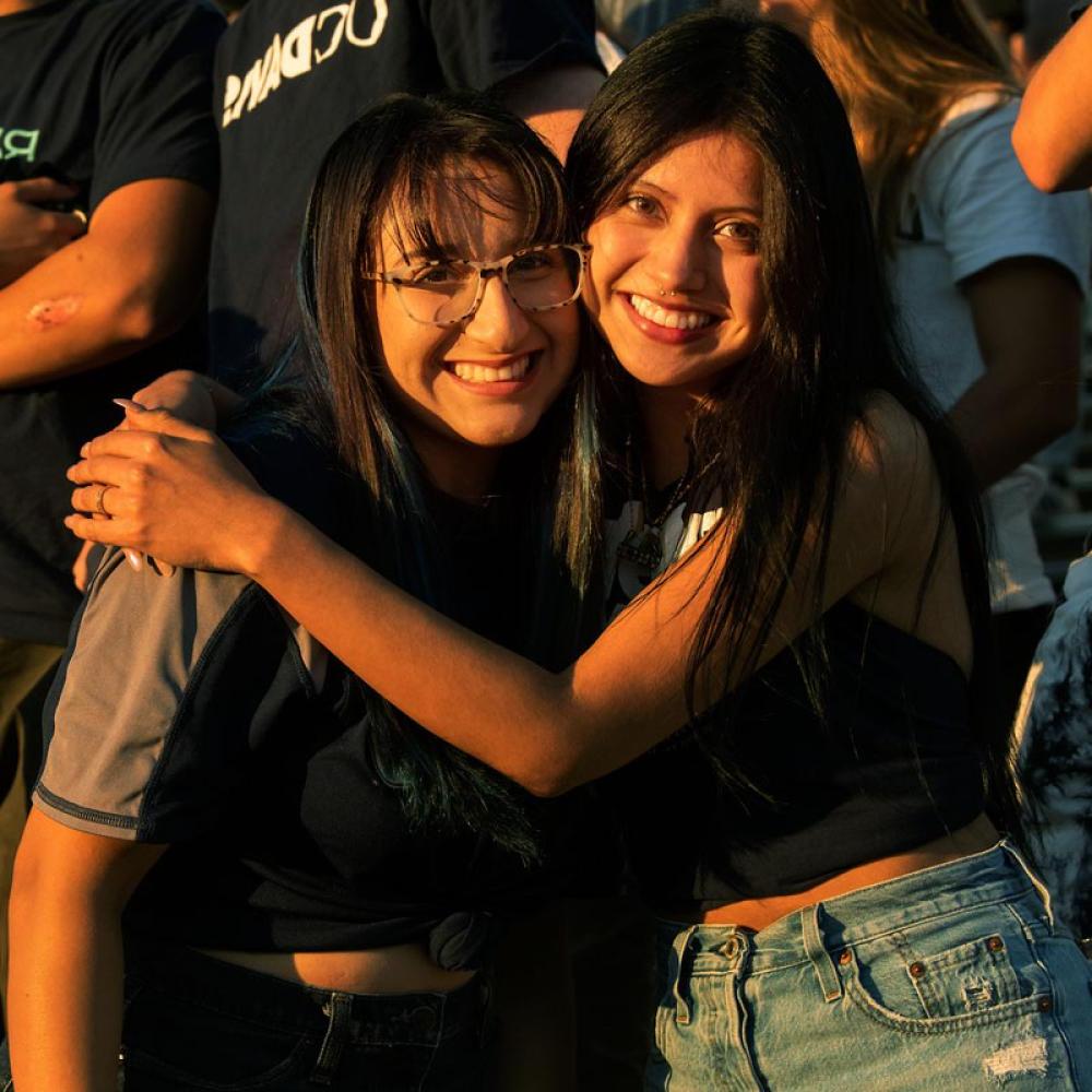 Two students hug at a UC Davis football game