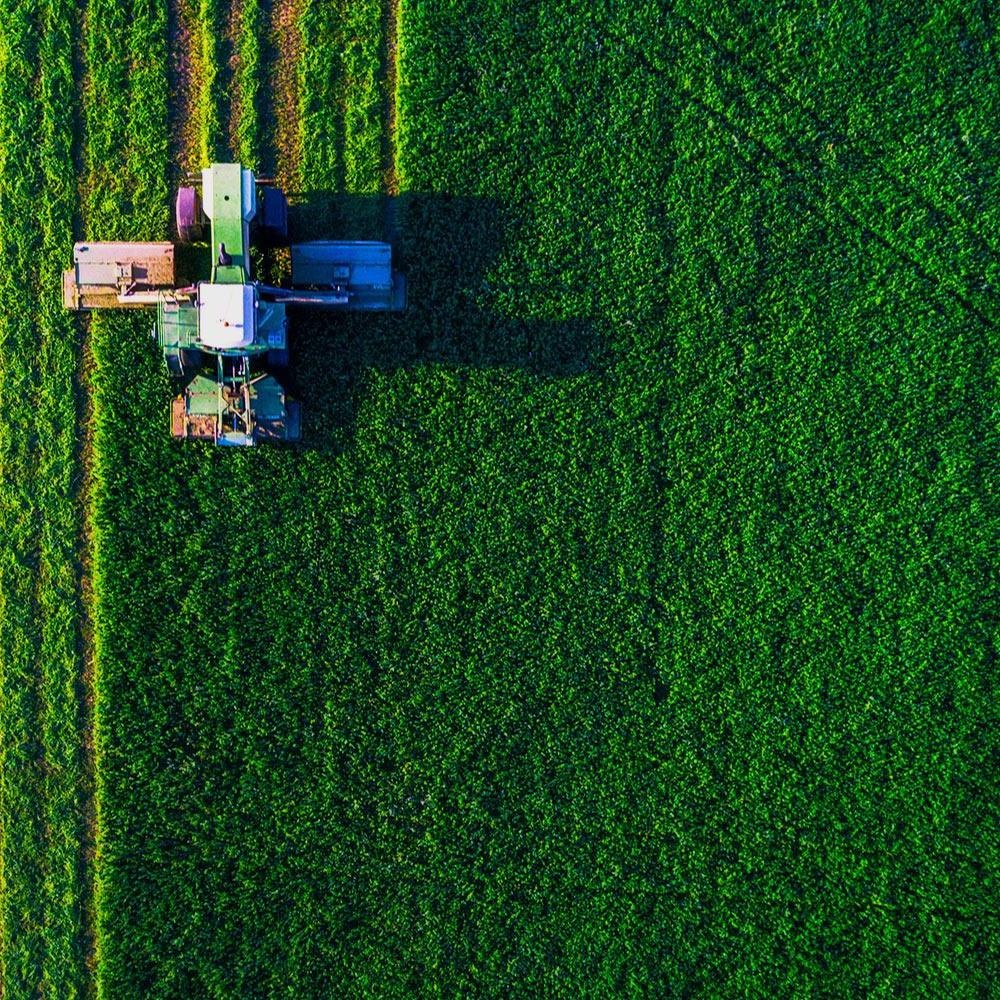 An overhead view of a combine working an agricultural field