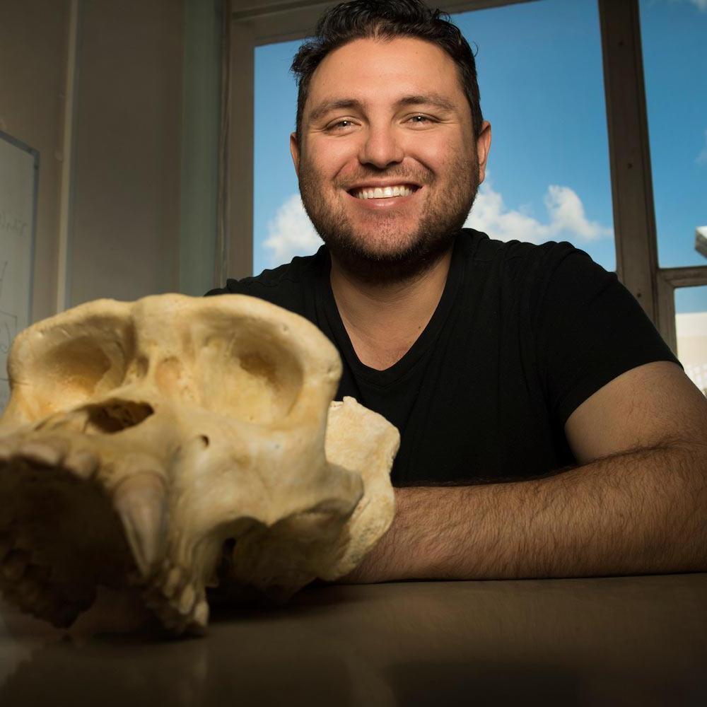 A student poses with an ape skull