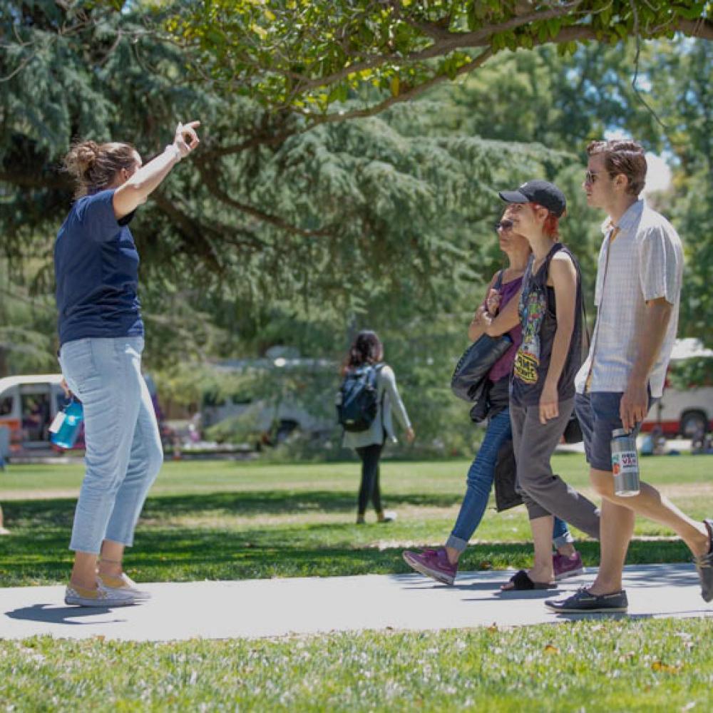 A UC Davis student tour guide leads a family through campus