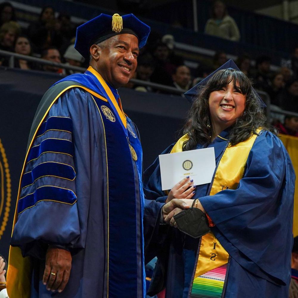 A UC Davis student shakes Chancellor May's hand at commencement