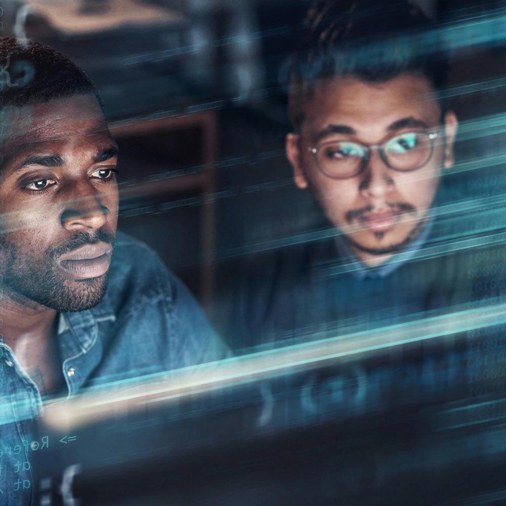 Two men look at a screen with code superimposed over the top of them