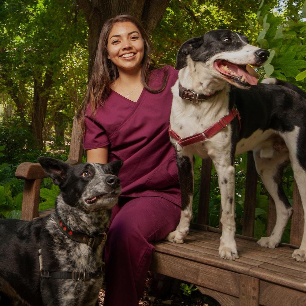 A female vet student poses with her two dogs